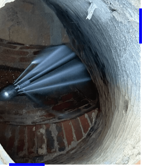 A metallic, fan-shaped object mounted on a brick and plaster wall.