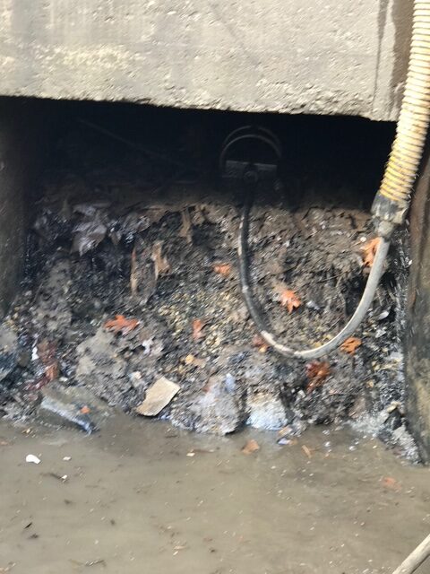 Drainage pipe with accumulated debris and water.