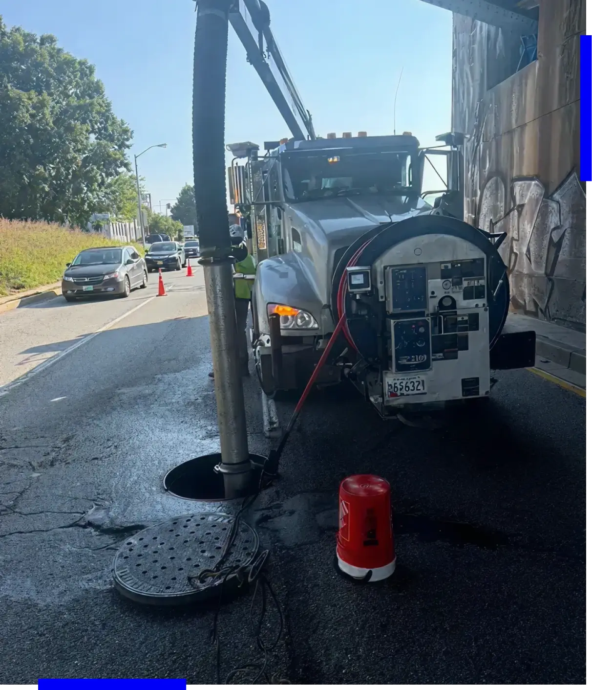 Truck cleaning sewer with vacuum hose.