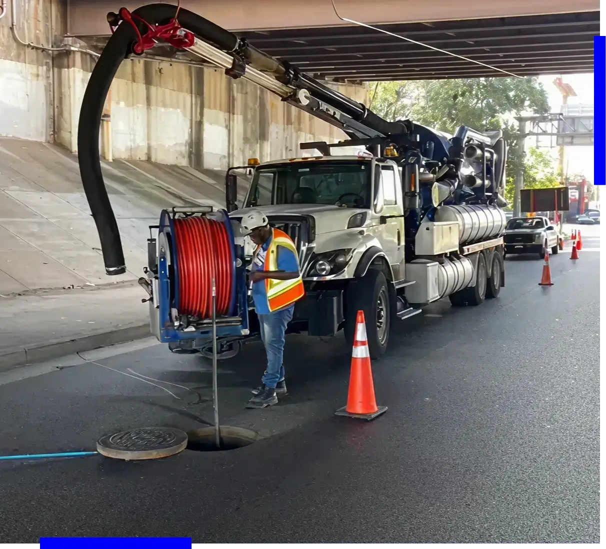 Truck cleaning sewer under bridge.